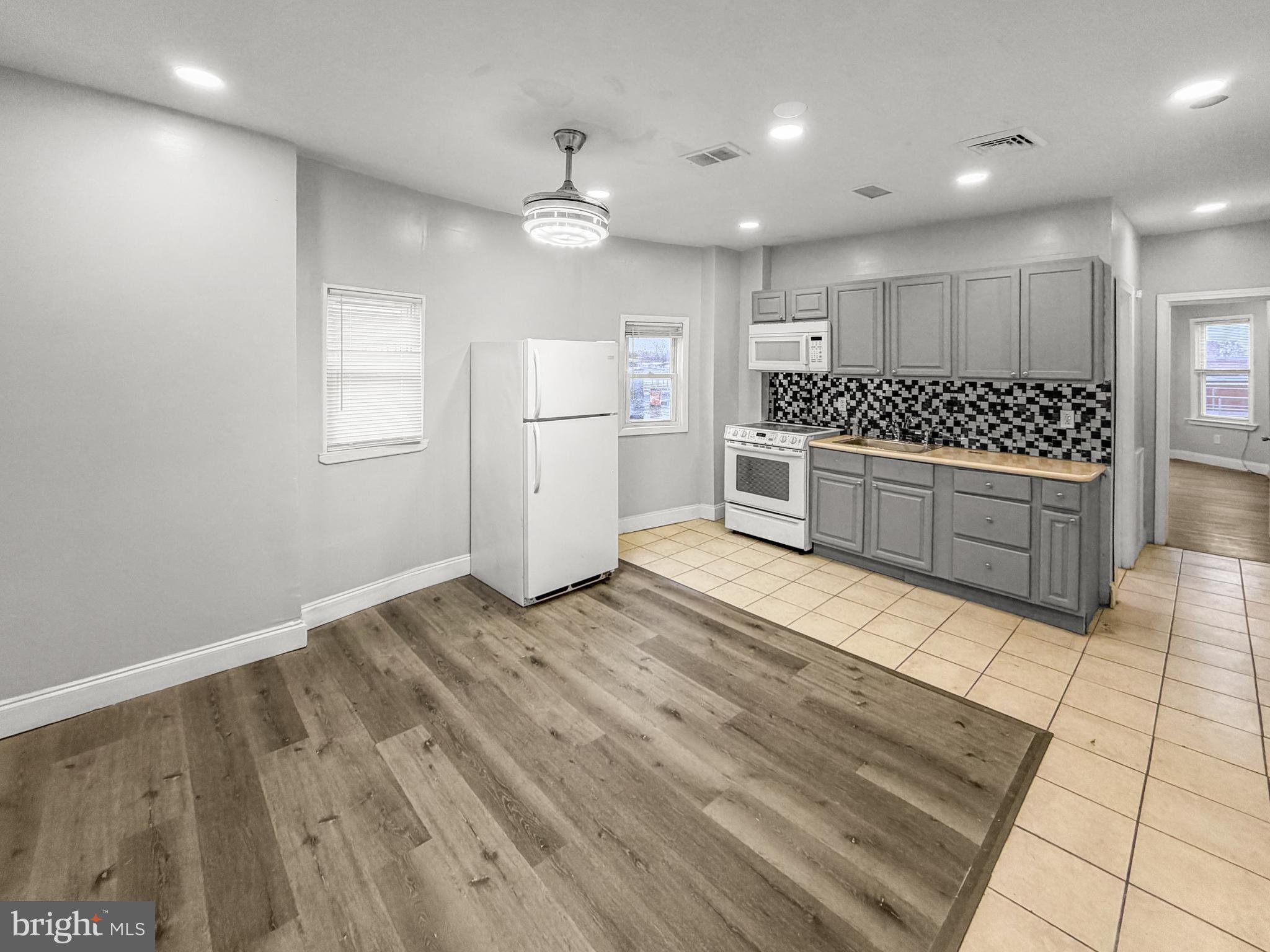 a large kitchen with a stove a sink and a refrigerator