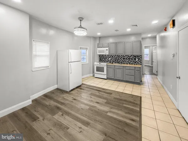 a large kitchen with a refrigerator and a stove
