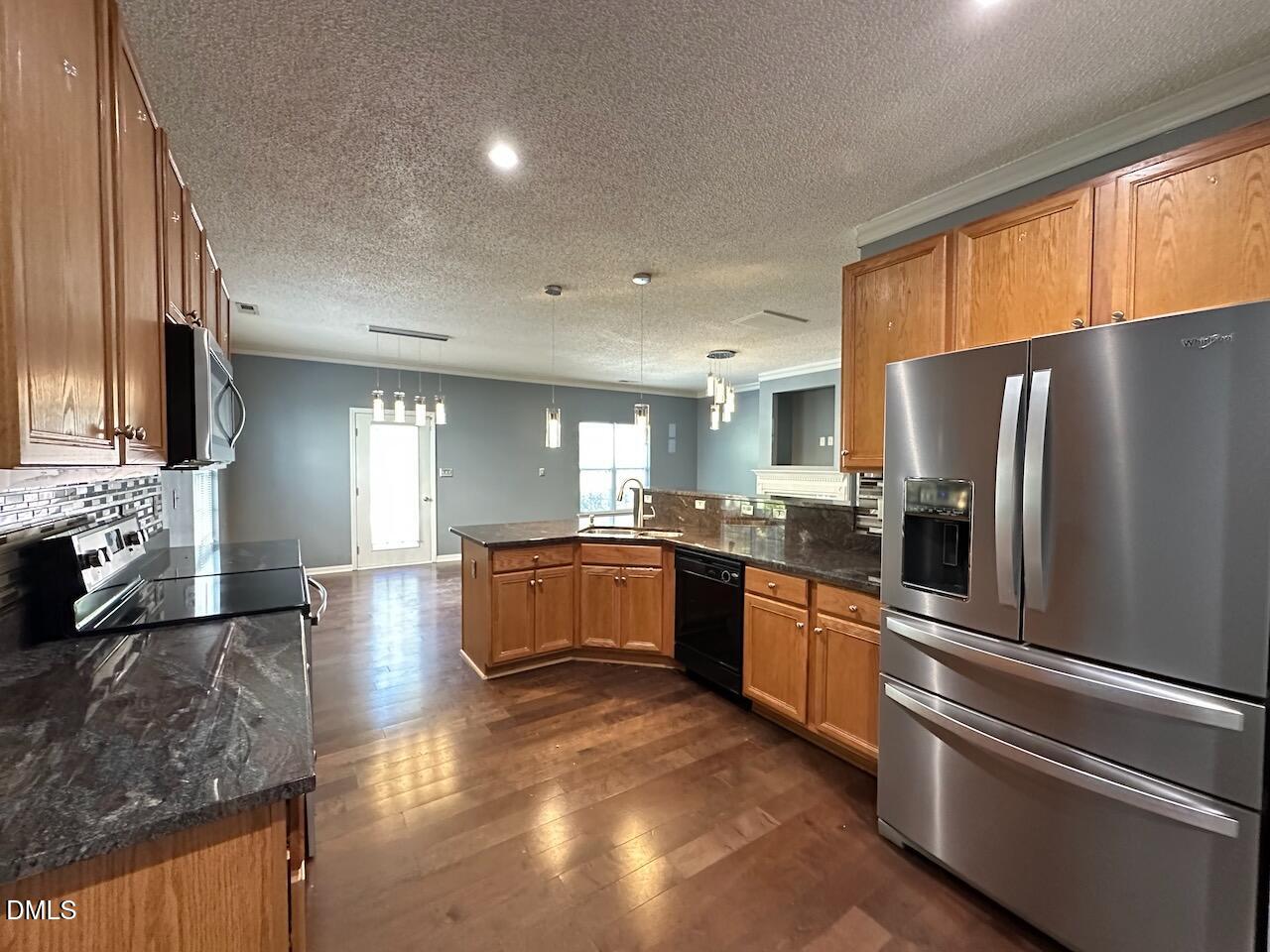 4617 Six Siblings Circle Raleigh, NC 27610 - Photo 11 of 35 a large kitchen with stainless steel appliances granite countertop a refrigerator a stove a sink a counter space and cabinets