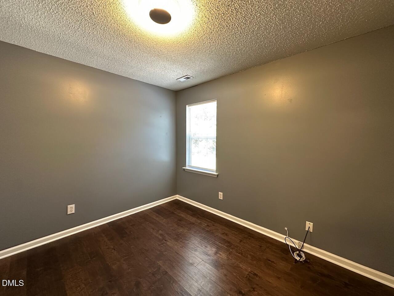 4617 Six Siblings Circle Raleigh, NC 27610 - Photo 34 of 35 an empty room with wooden floor and windows