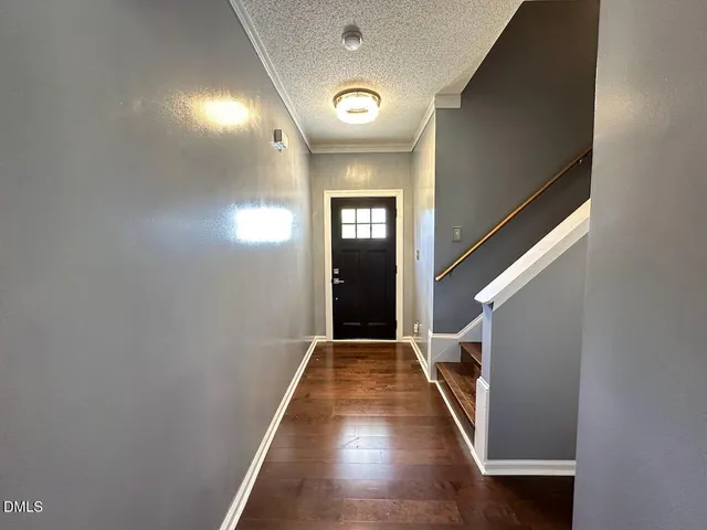 a view of a hallway with wooden floor and staircase