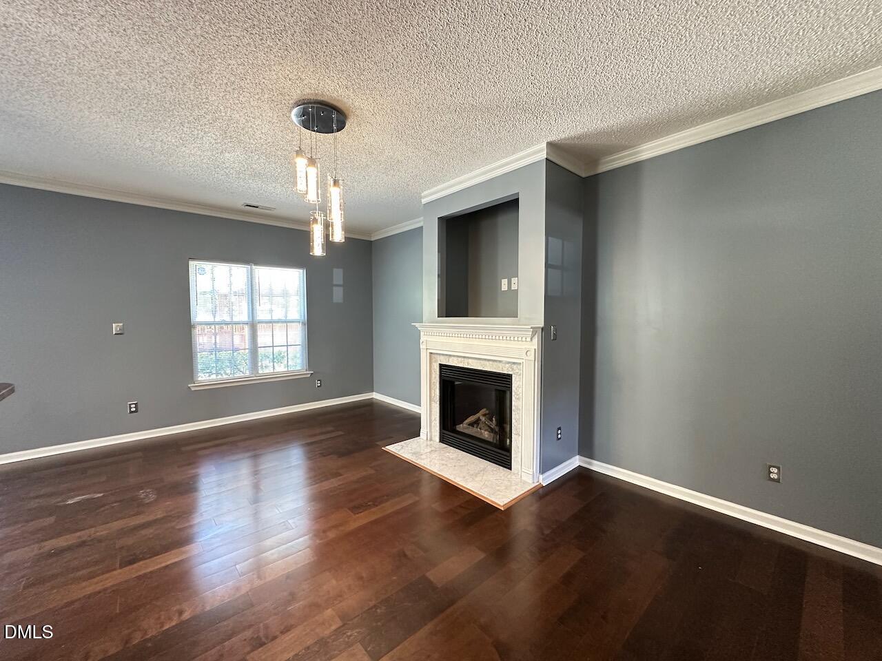 4617 Six Siblings Circle Raleigh, NC 27610 - Photo 5 of 35 a view of an empty room with wooden floor fireplace and a window