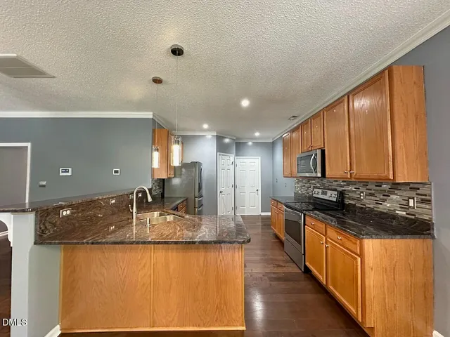 a large kitchen with kitchen island granite countertop a large counter top and stainless steel appliances