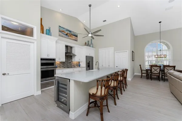 a large white kitchen with a sink and dishwasher