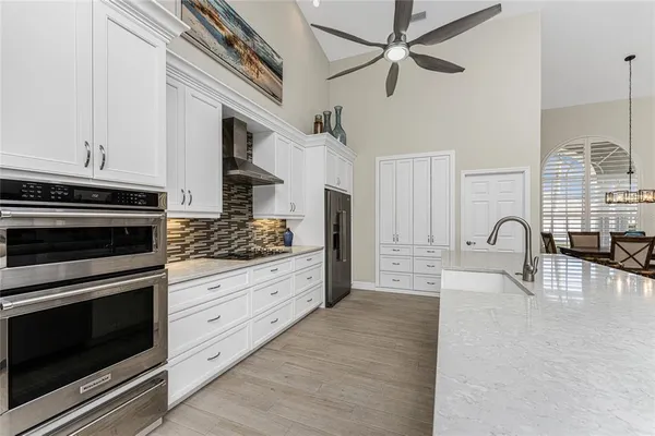 a large white kitchen with stainless steel appliances and white cabinets