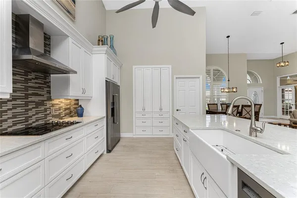 a large white kitchen with a large window and stainless steel appliances