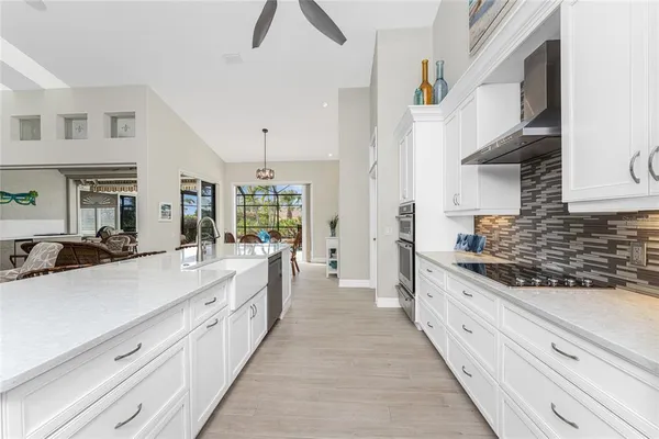 a kitchen with stainless steel appliances granite countertop a sink a stove and white cabinets