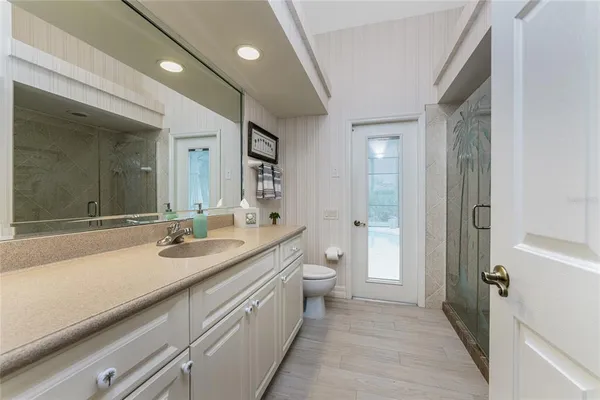 a room with chandelier fan and a wooden floor