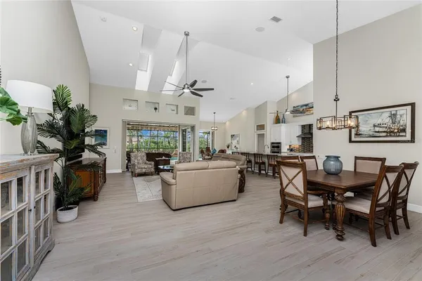 a living room with furniture kitchen view and a chandelier