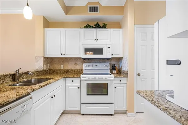 a living room with furniture a chandelier and a large window