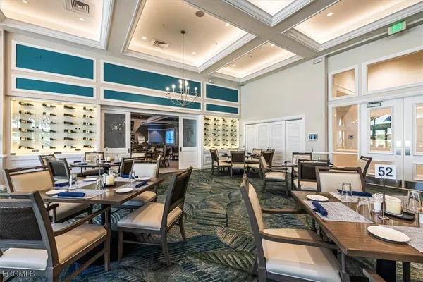 a kitchen with stainless steel appliances kitchen island granite countertop a table chairs and a large window