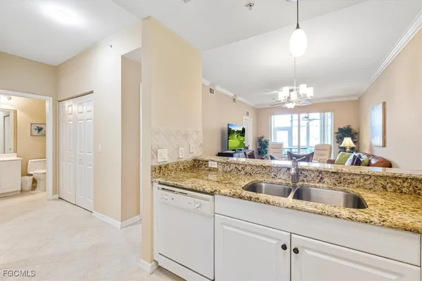a kitchen with granite countertop a sink stove and refrigerator