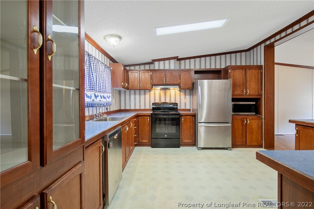 922 Magnolia Church Road Stedman, NC 28391 - Photo 15 of 49 a kitchen with refrigerator a microwave and furniture