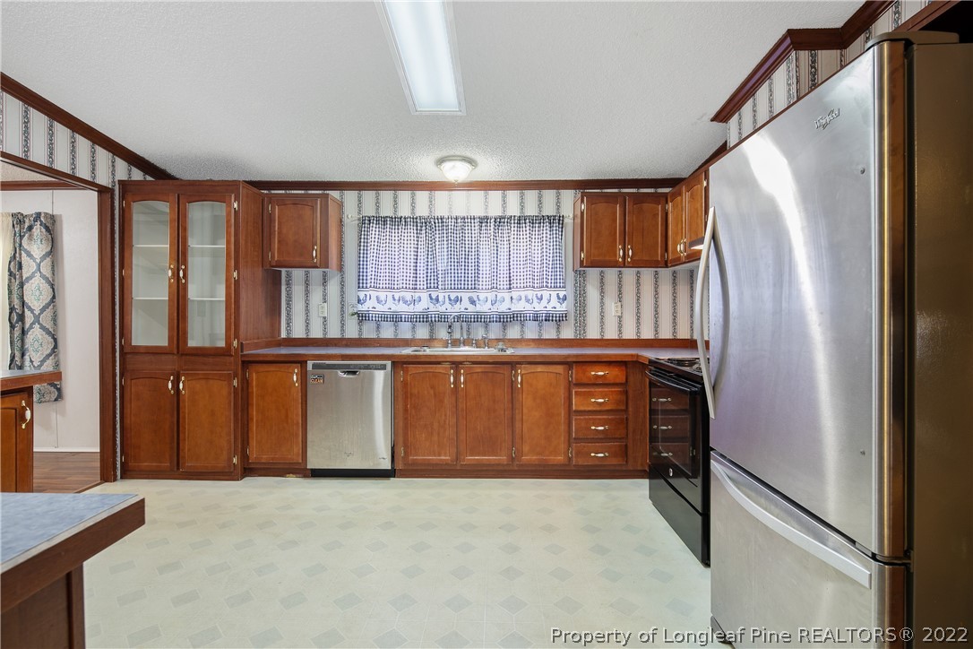922 Magnolia Church Road Stedman, NC 28391 - Photo 18 of 49 a kitchen with stainless steel appliances granite countertop a refrigerator a sink and a stove
