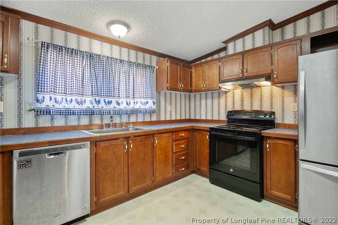 922 Magnolia Church Road Stedman, NC 28391 - Photo 19 of 49 a kitchen with stainless steel appliances granite countertop a stove a sink and a microwave
