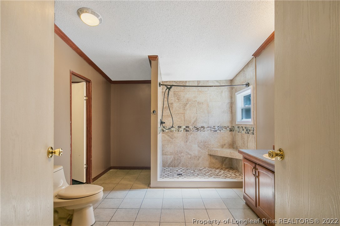 922 Magnolia Church Road Stedman, NC 28391 - Photo 28 of 49 a bathroom with a glass shower door