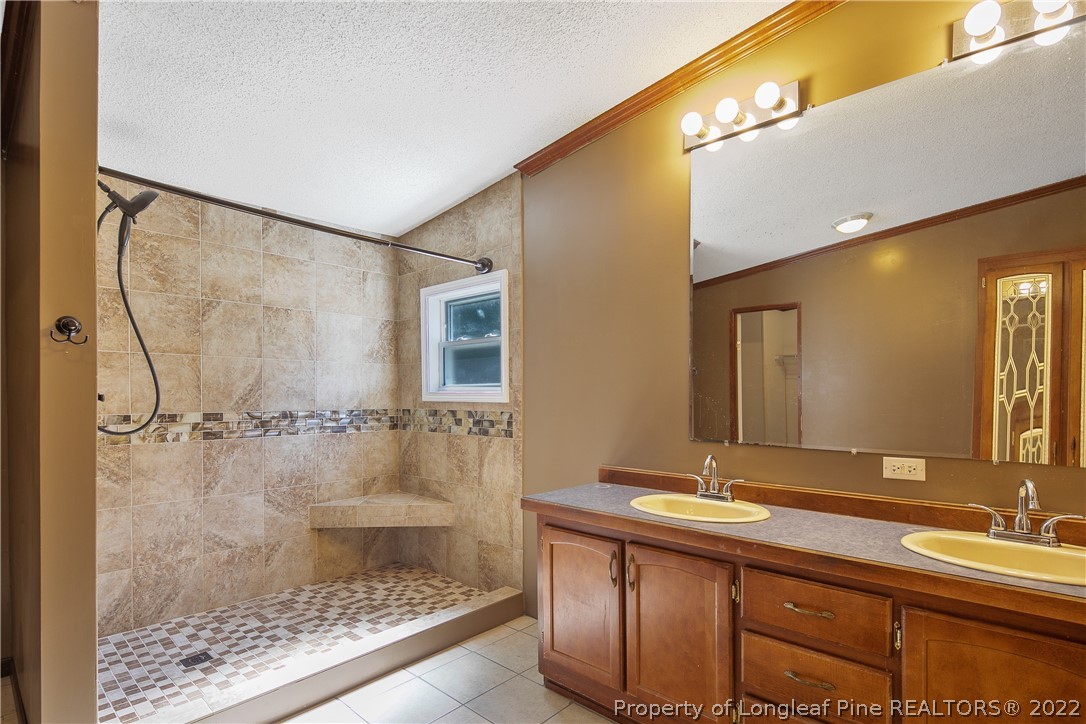 922 Magnolia Church Road Stedman, NC 28391 - Photo 29 of 49 a bathroom with a double vanity sink and mirror