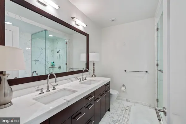 a bathroom with a double vanity sink mirror and toilet