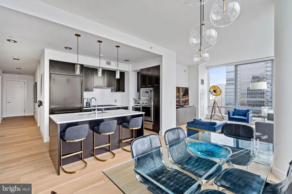 a living room with granite countertop furniture a rug and kitchen view