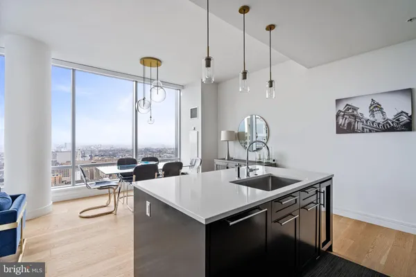 a kitchen with a sink a large window and chairs