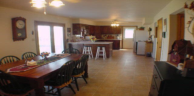 16955 Hartman Road Davis, IL 61019 - Photo 4 of 5 a kitchen with a table chairs refrigerator and cabinets