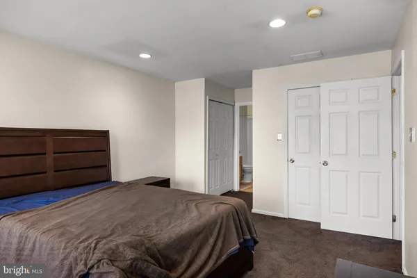 a spacious bedroom with a bed and cabinet
