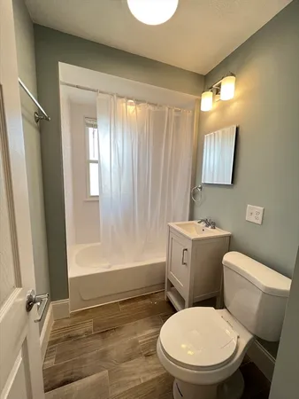 a white toilet sitting next to a bathroom sink and a tub