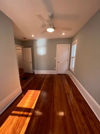 a view of an empty room with wooden floor