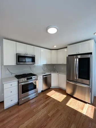 a kitchen with granite countertop a refrigerator and a stove top oven