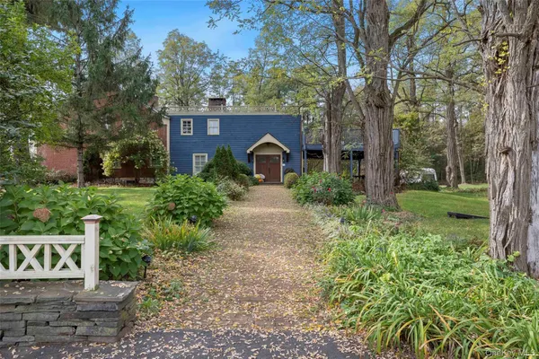 a red brick house with a big yard and large trees