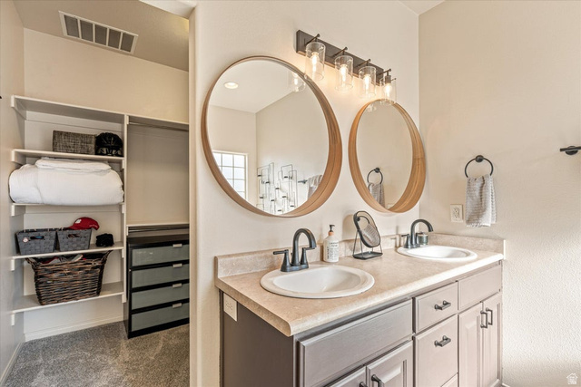 345 North 2450th Street East, Unit 152 St. George, UT 84790 - Photo 20 of 40 Full bathroom with double vanity, a spacious closet, and dark colored carpet