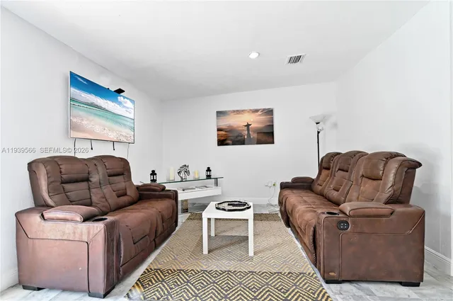 a living room with furniture a couch and two windows