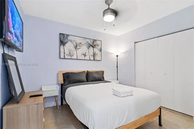 a bedroom with a bed and a flat screen tv