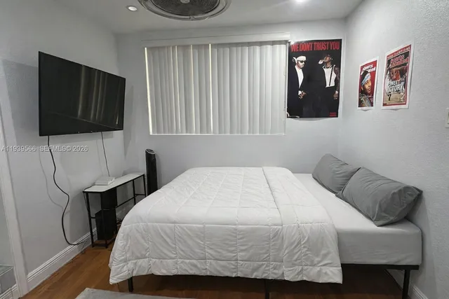 a bedroom with a bed and flat screen tv
