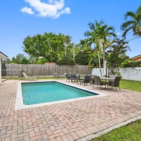 a view of a swimming pool with a patio and a yard