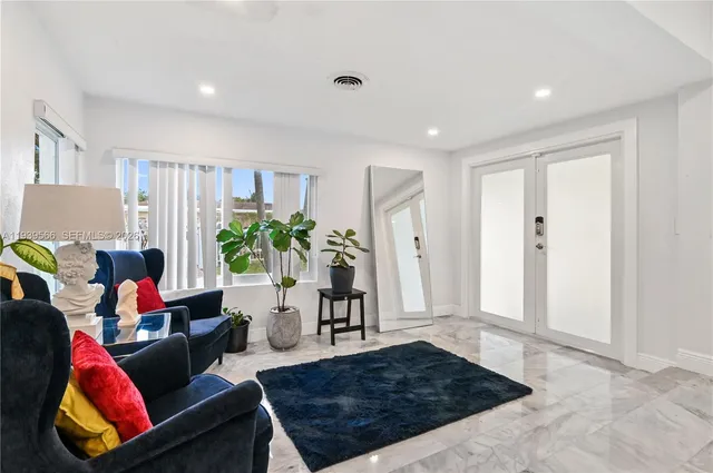 a living room with furniture rug and a potted plant