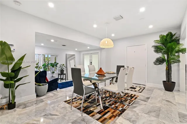 a view of a dining room with furniture and a potted plant