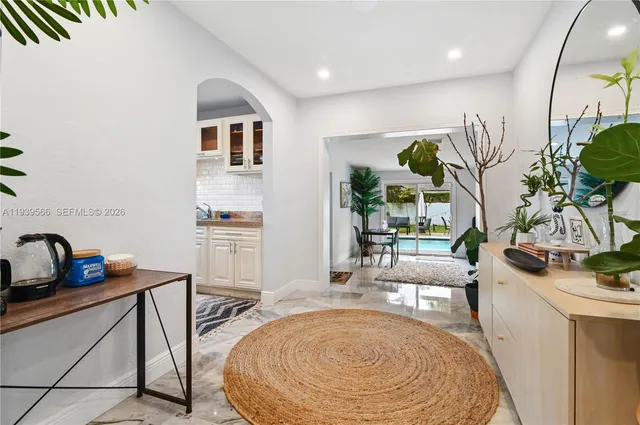 a living room with fireplace furniture and a potted plant