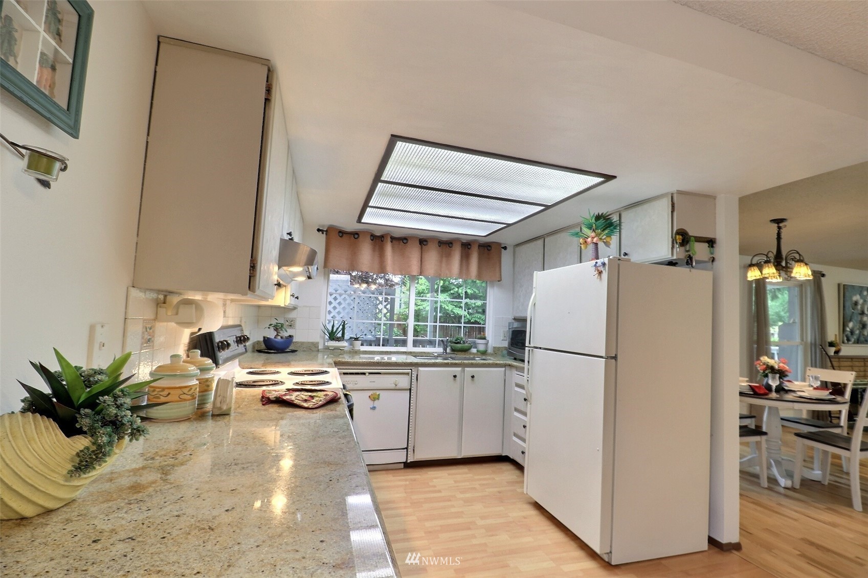 17234 139th Place Southeast Renton, WA 98058 - Photo 13 of 36 a kitchen with a refrigerator a white cabinets and wooden floor