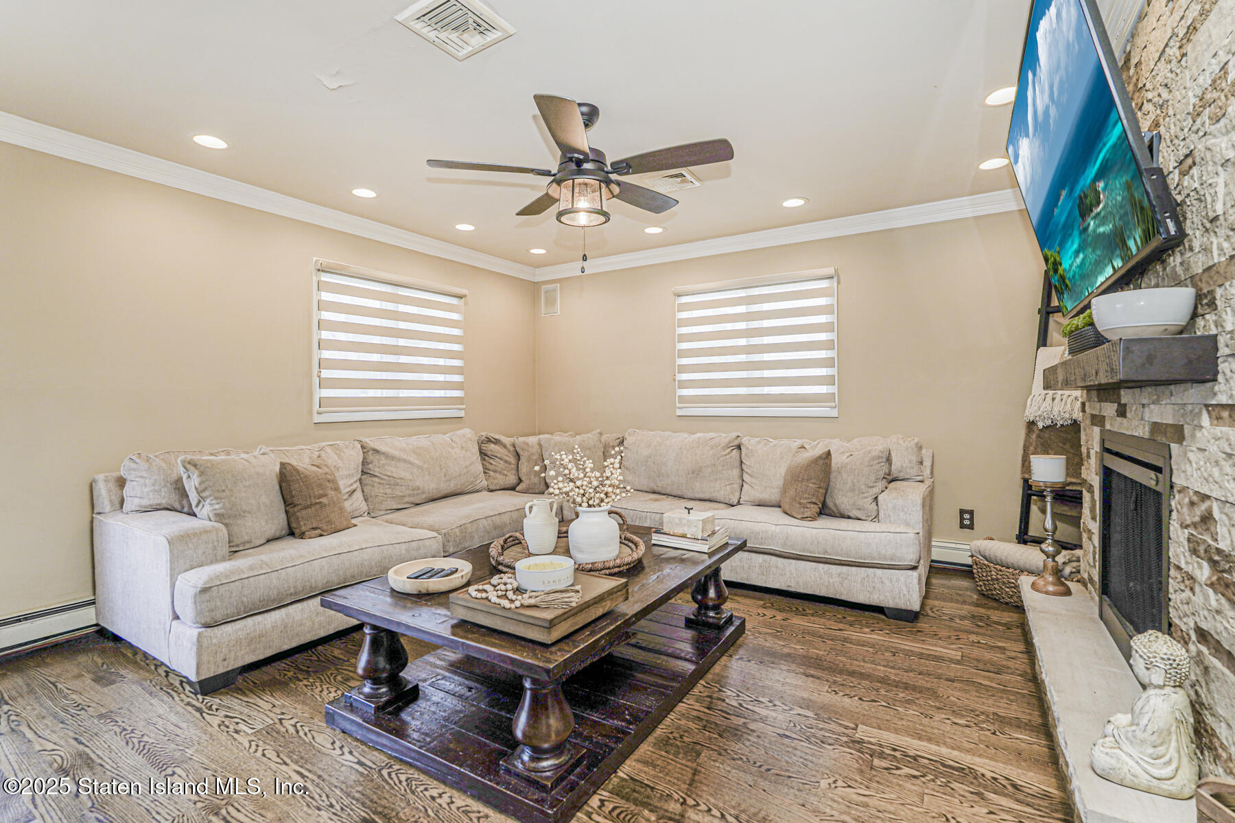 191 Rensselaer Avenue Staten Island, NY 10312 - Photo 23 of 36 a living room with furniture a fireplace and a flat screen tv