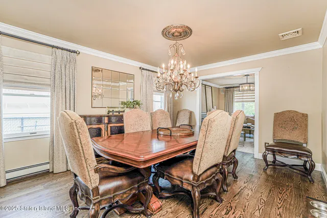 a dining room with furniture a chandelier and wooden floor