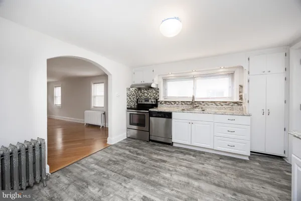 a kitchen with granite countertop white cabinets and appliances