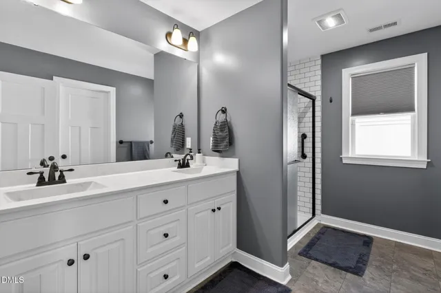a bathroom with a double vanity sink and a mirror