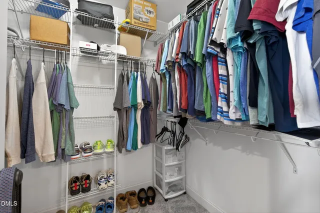 a view of walk in closet with clothes and shoes