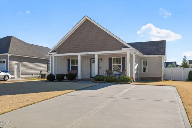 a front view of a house with a yard and potted plants
