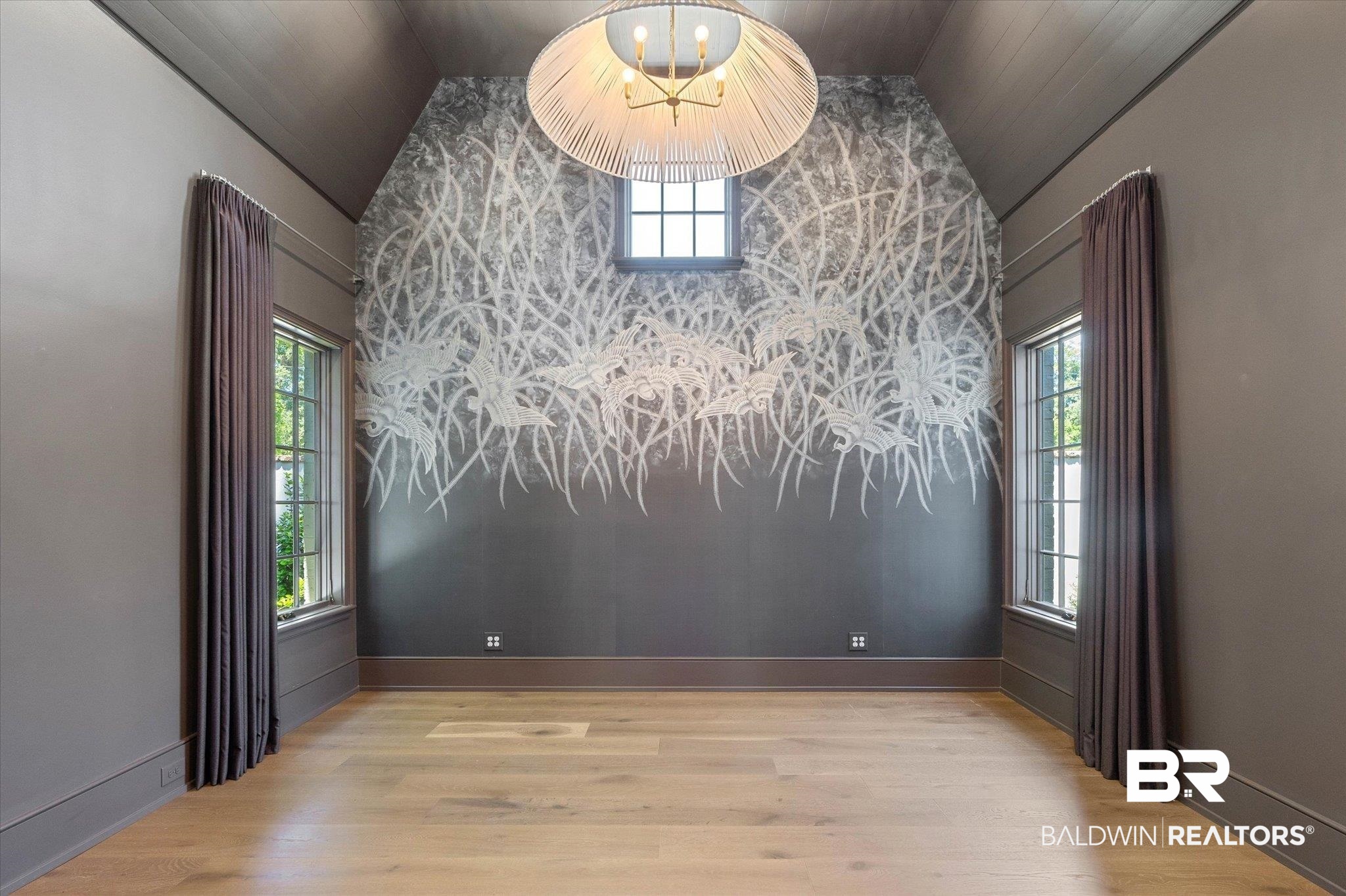 3 Canterbury Park Mobile, AL 36608 - Photo 16 of 43 Empty room featuring vaulted ceiling, wood finished floors, a chandelier, baseboards, and an accent wall