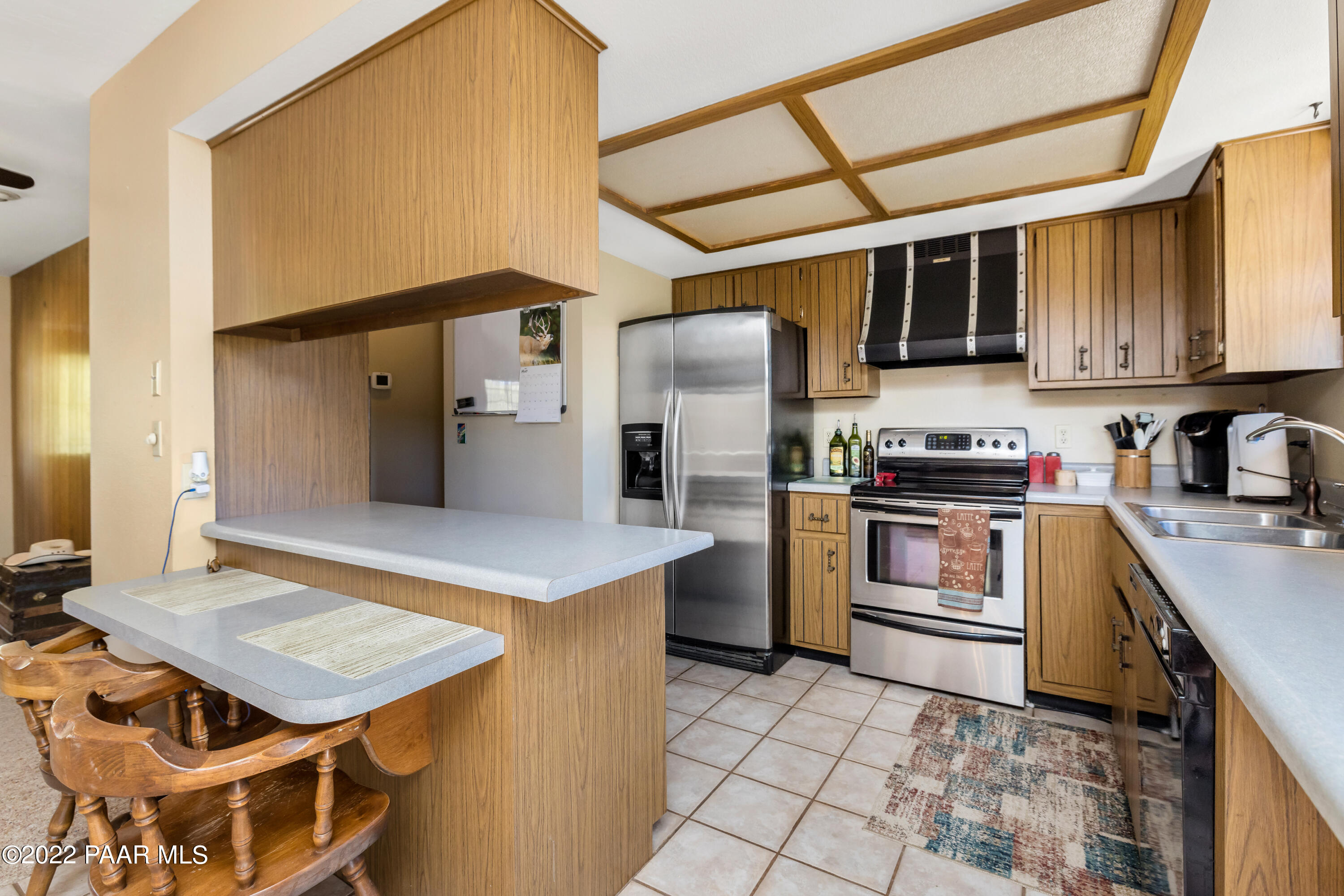 1481 West Cliff Rose Road Prescott, AZ 86305 - Photo 10 of 38 a kitchen with stainless steel appliances a stove a refrigerator and cabinets