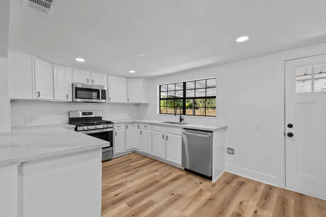 an empty room with windows and ceiling fan