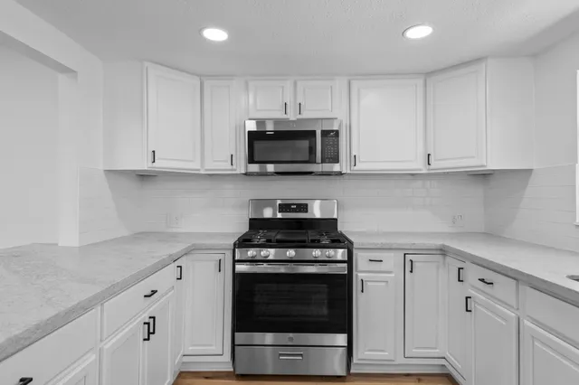 a view of empty room with wooden floor and window