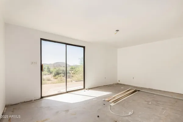 an empty room with windows and fan